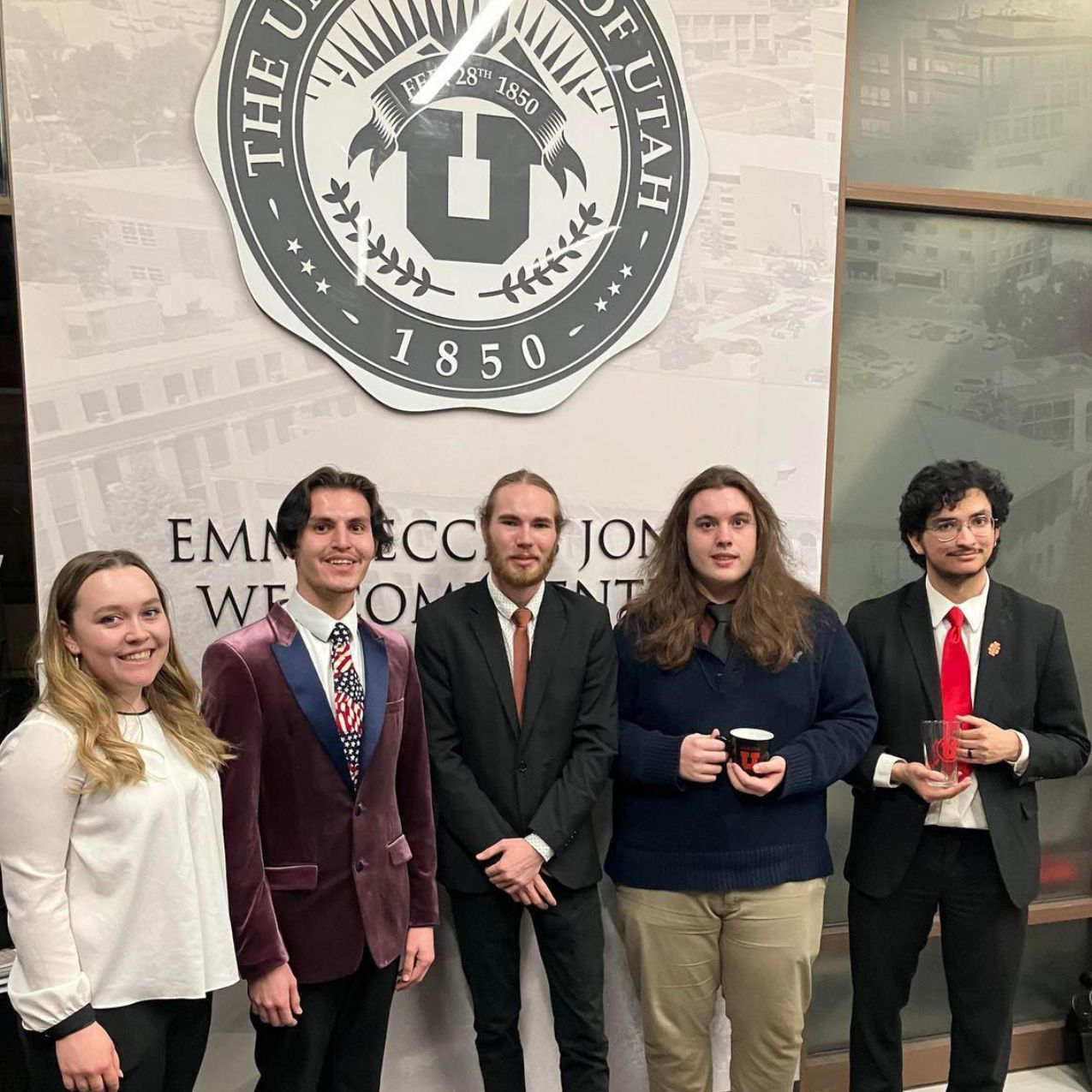 Rupp Debate team members stand holding a trophy from a debate tournament win