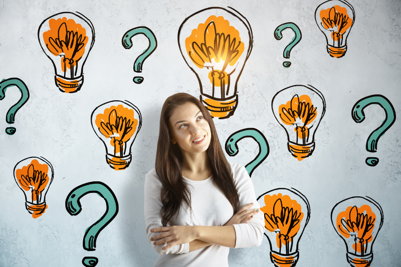 girl with question marks and light bulbs around her