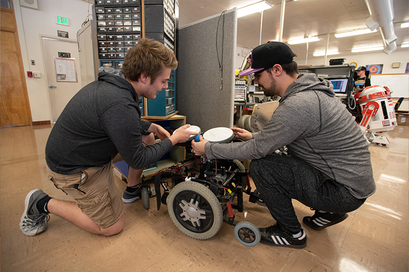 Robotics and Communications Systems Engineering Technology student working in Lab with instructors