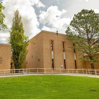 brick building with trees and green turf