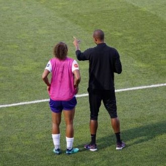 African American male coach with female college athlete