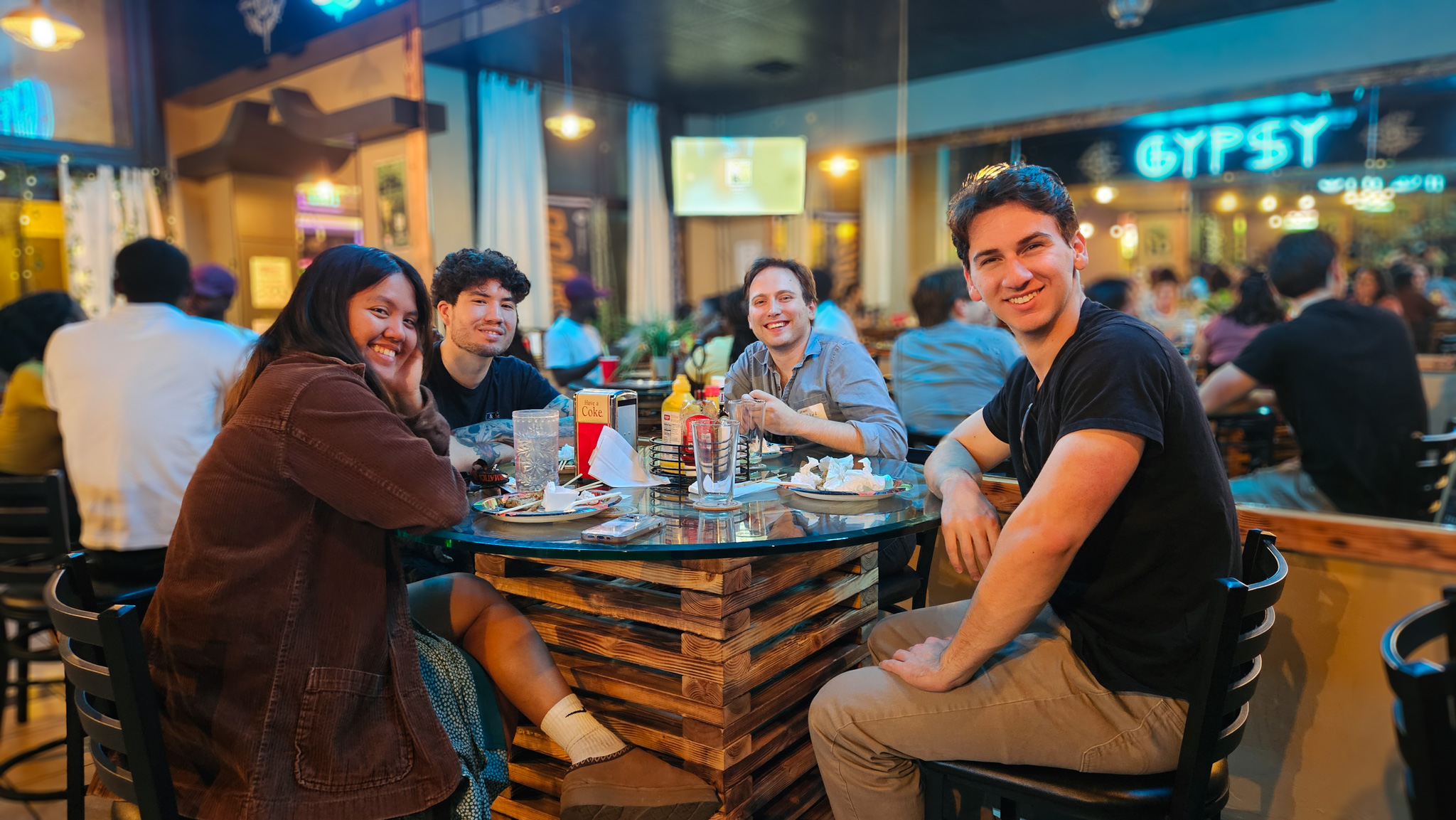 4 students sitting around a table with drinks at Late Nights with the Graduate School