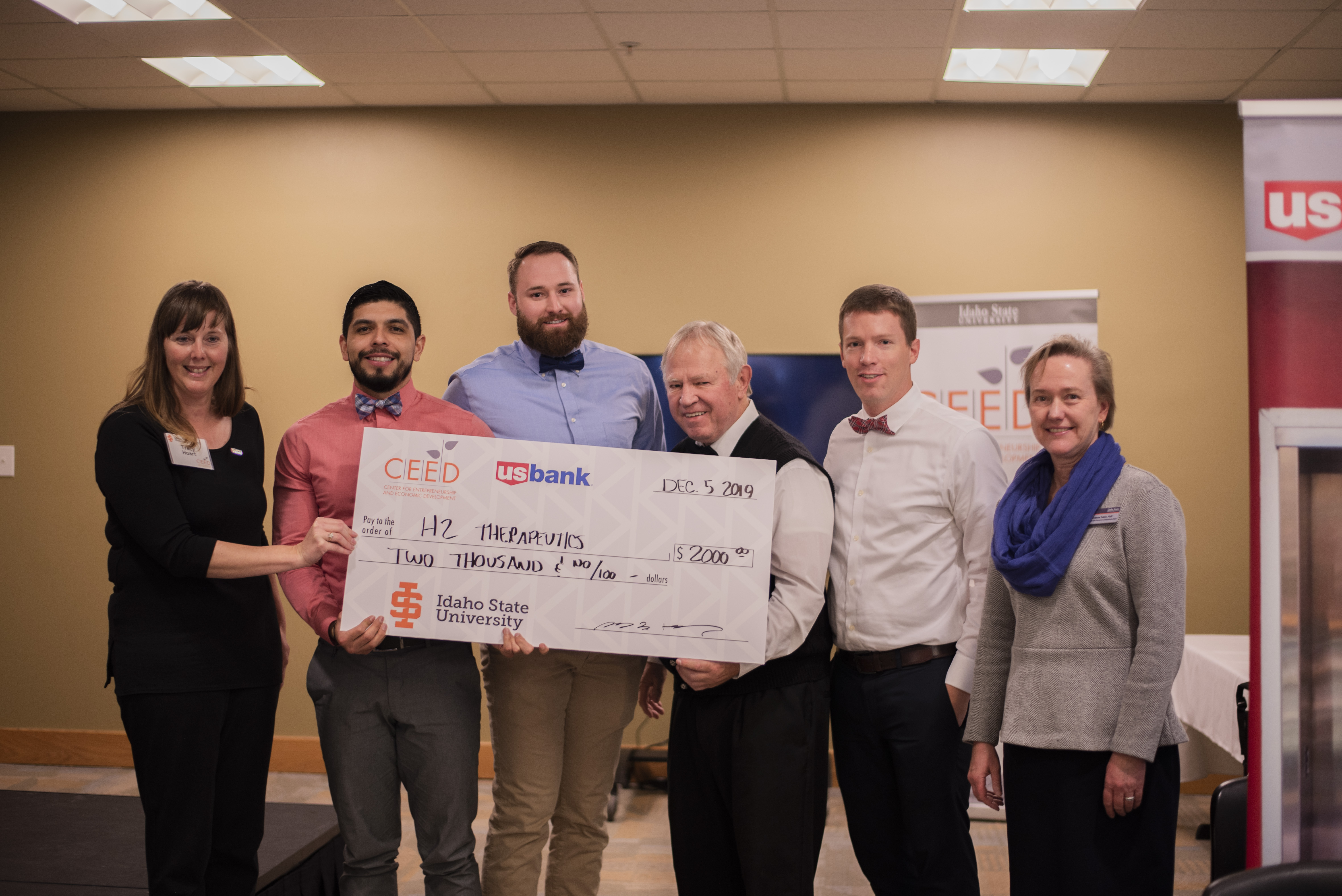 COP students Hugo Rayo, Will Cannon and faculty Kerry Casperson and Jared Barrott accept an oversized $2000 check from CEED