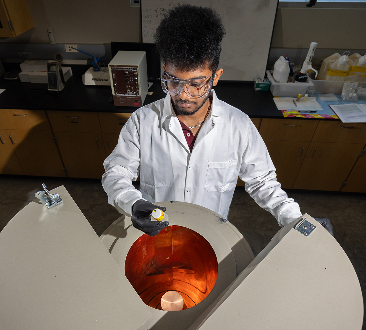 Student standing over instrument