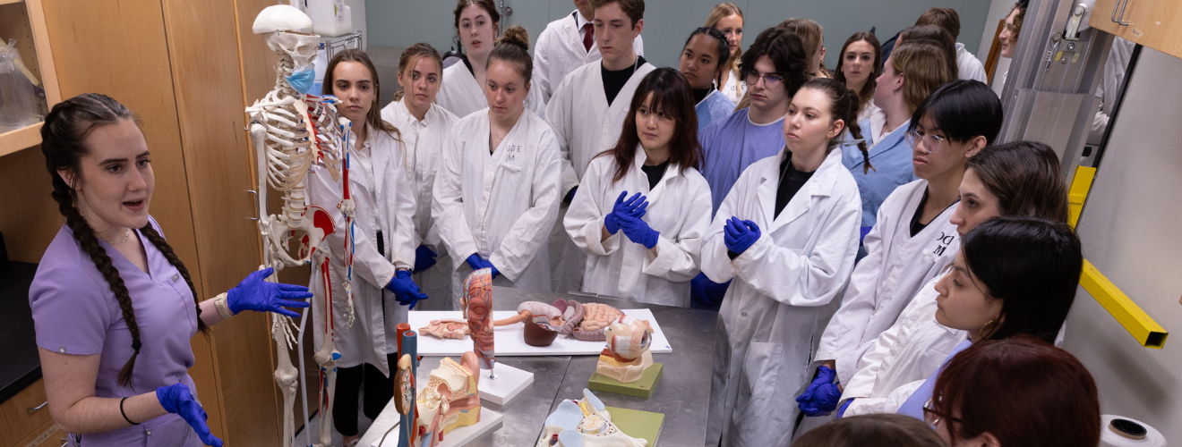 A picture of a demonstration of anatomy in front of high school students