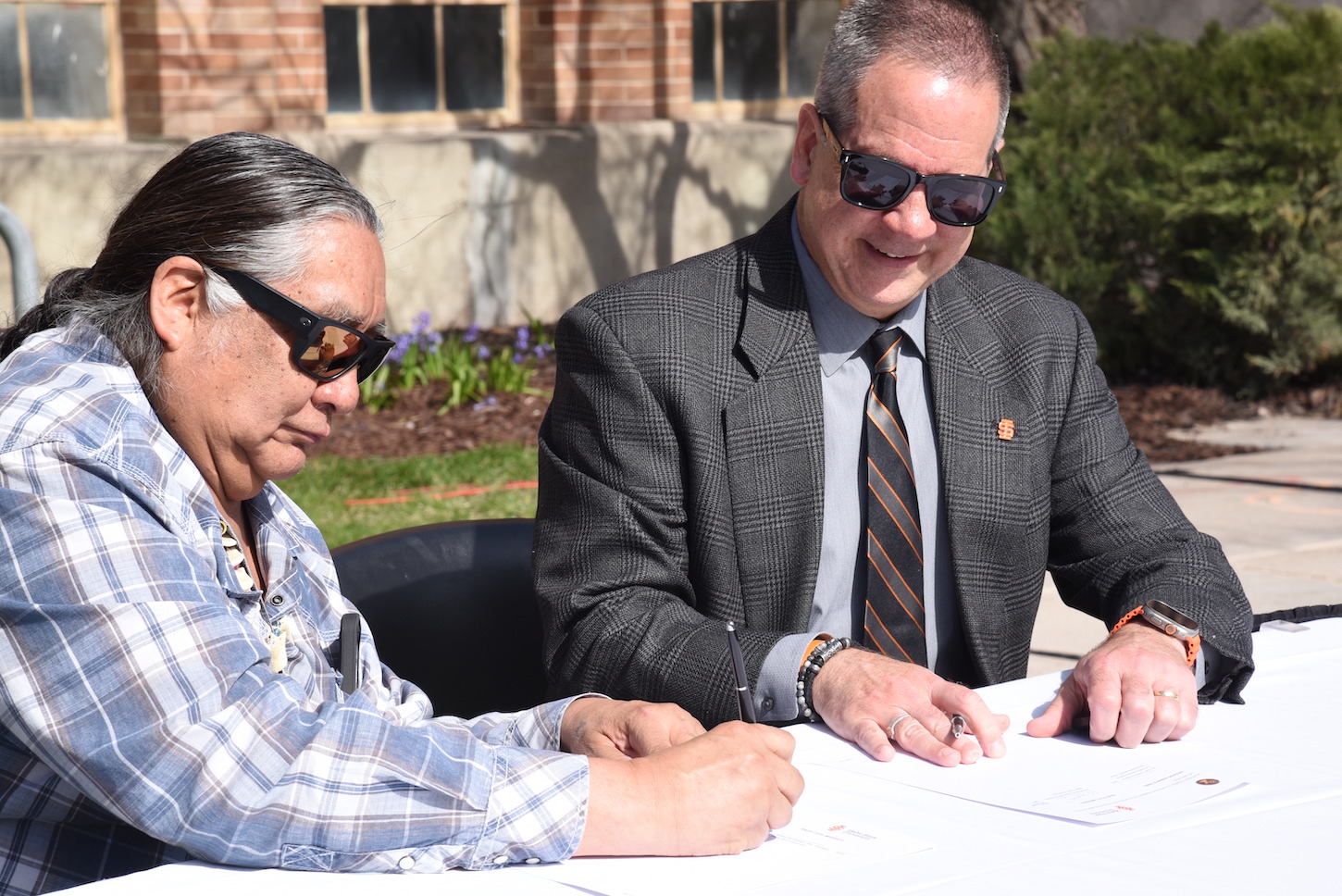 Two men sign a paper